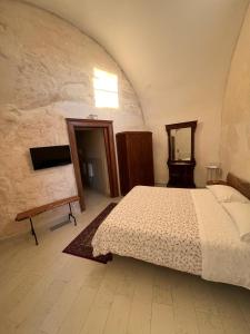 een slaapkamer met een bed en een spiegel bij Locus Amoenus in Matera