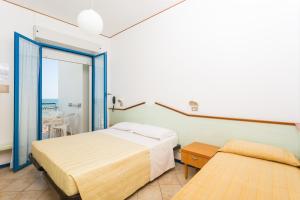 a bedroom with two beds and a balcony at Hotel Bellaria in Bellaria-Igea Marina
