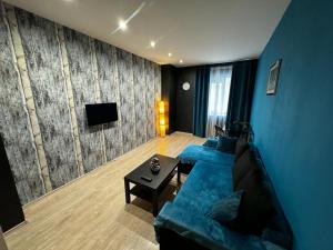 a living room with a blue couch and a tv at Romance Suites in Bucharest