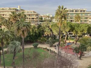 a view of a park with palm trees and buildings at Appartement 2 pièces meublés à Juan Les Pins in Antibes
