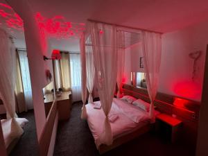 a bedroom with a bed with red lights in it at Romance Suites in Bucharest