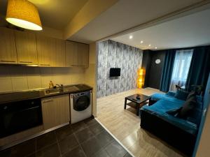 a kitchen and a living room with a blue couch at Romance Suites in Bucharest