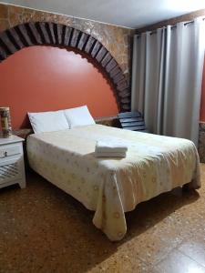 a bed in a room with a brick wall at Hotel Posada El Gran Cipres in San Cristóbal de Las Casas