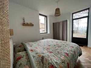 una camera da letto con un letto con copriletto floreale di Maison pleine de charme avec piscine et jardin a Pujols