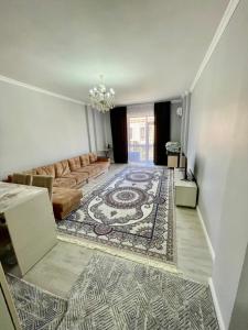 a living room with a couch and a rug at Keruen Saray Apartments в центре города in Türkistan