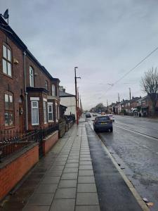 a sidewalk with a car parked on the side of a street at Stunning 3-Bed House in Manchester in Manchester