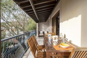 包內伊的住宿－Home Gioia Santa Maria，阳台的门廊配有木桌和椅子