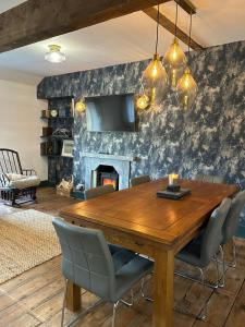 comedor con mesa de madera y chimenea en Dolgellau Grand Heights Apt, en Dolgellau