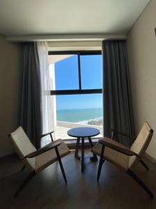 a room with two chairs and a table and a window at APEC MANDALA CONDOTEL - Mui Ne in Mui Ne