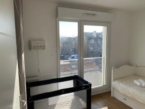 a room with a bed and a glass door with a window at Le 147 Parc Entre Paris et Disney in Champigny-sur-Marne