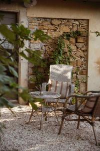 una mesa y una silla junto a una pared de piedra en Maison Bellamant, en Alan