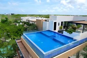 una vista aérea de una casa con piscina en BEAUTIFUL SUIT WITH INFINITY POOL AND GYM IN THE MIDDLE OF THE JUNGLe and grill, en Tulum