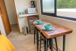 una pequeña cocina con una mesa de madera con dos tazas. en BEAUTIFUL SUIT WITH INFINITY POOL AND GYM IN THE MIDDLE OF THE JUNGLe and grill, en Tulum
