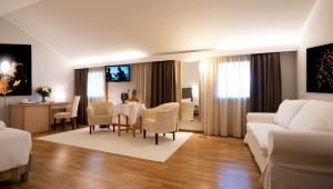 sala de estar con mesa y sofá blanco en Golf Club Padova - Relais Graya, en Galzignano Terme