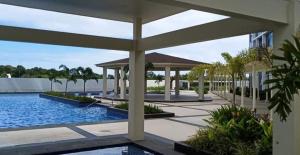a building with a swimming pool and a pavilion at Mactan Newtown By The Beach in Lapu Lapu City