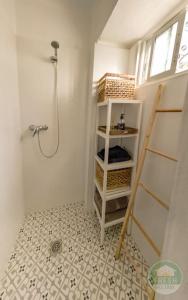 a small bathroom with a shower and a shelf at Casitalonga - NEW studio apartment in Sayalonga in Sayalonga