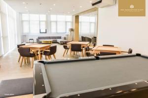 a pool table in a room with tables and chairs at Mactan Newtown By The Beach in Lapu Lapu City
