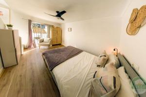 a bedroom with a large bed and a fan at Casitalonga - NEW studio apartment in Sayalonga in Sayalonga