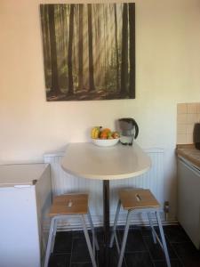 a table with a bowl of fruit and two stools at CENTRAL LOCATION! Double Bedroom 2 Mins Walk from Battersea Power underground Station! in London