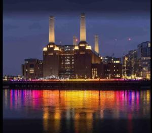 a view of a factory at night with the water at CENTRAL LOCATION! Double Bedroom 2 Mins Walk from Battersea Power underground Station! in London