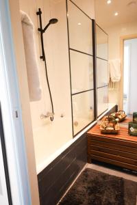 La salle de bains est pourvue d'une baignoire, d'une douche et d'un lavabo. dans l'établissement Furnished - Bright, Modern apartment in Brussels, 15 minutes walk from the Atomium, à Bruxelles