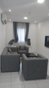 برج الوطن للاجنحه الفندقية في مكة المكرمة: غرفة معيشة مع كنبتين وتلفزيون