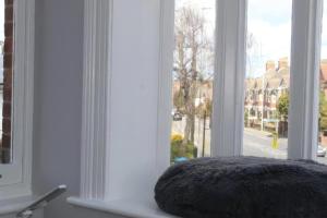 a pillow sitting on a window sill looking out at a street at Lovely 2 Bed 2 Bath Flat with FREE Parking in Poole