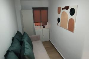a living room with a couch and a painting on the wall at Apartamento Entero Juzgados Alicante in Alicante
