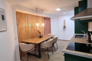 a kitchen with a wooden table and some chairs at Apartamento Entero Juzgados Alicante in Alicante