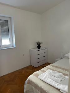 ein Schlafzimmer mit einem Bett mit einer Kommode und einem Fenster in der Unterkunft GOKI near airport and city, sea view in Kaštel Sućurac