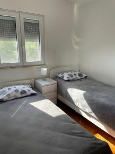 2 Einzelbetten in einem Schlafzimmer mit 2 Fenstern in der Unterkunft GOKI near airport and city, sea view in Kaštel Sućurac