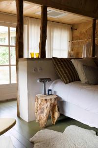 1 dormitorio con 1 cama y 1 mesa de tronco de árbol en Maison Bellamant, en Alan