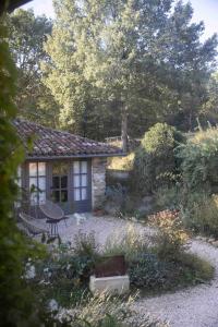 a house with a table and a chair in a yard at Maison Bellamant in Alan +58 photos