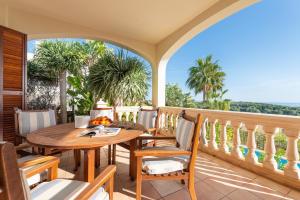 a porch with a wooden table and chairs on a balcony at Villa Bendinat 10 in Calvia Town