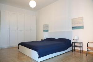 1 dormitorio con 1 cama azul y armarios blancos en Ampio bilocale in centro con parcheggio gratuito nella proprietà, vicino a stazione Como-Milano, en Erba