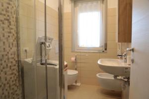 La salle de bains est pourvue de toilettes et d'un lavabo. dans l'établissement Ampio bilocale in centro con parcheggio gratuito nella proprietà, vicino a stazione Como-Milano, à Erba