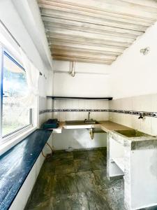 eine leere Küche mit einem Waschbecken und einem Fenster in der Unterkunft Apartamentos Coveñas in Coveñas