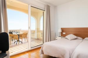 a bedroom with a bed and a balcony with a table at Villa Bendinat 10 in Calvia Town +32 photos