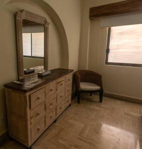 a dresser with a mirror and a chair in a room at Encantador Condo de 3 Recamaras en Velas Vallarta in Puerto Vallarta