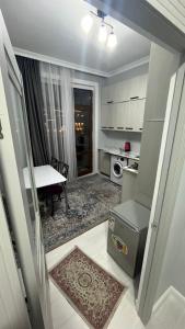 a small kitchen with a table and a dining room at Keruen Saray Apartments 2 in Türkistan