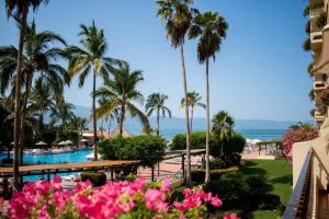 a view of a resort with palm trees and a swimming pool at Encantador Condo de 3 Recamaras en Velas Vallarta in Puerto Vallarta