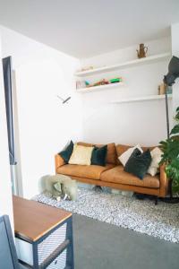 un soggiorno con divano e cuscini sopra di Furnished - Bright, Modern apartment in Brussels, 15 minutes walk from the Atomium a Bruxelles