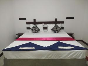 a bedroom with a large bed with two pillows at Yashi's Place Sigiriya in Sigiriya