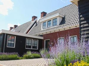 uma casa de tijolos vermelhos com telhado de azulejo em Beautiful holiday home in Colijnsplaat with garden em Colijnsplaat
