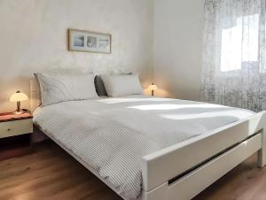 a white bed in a bedroom with a window at Bed and Breakfast Cattinara in Trieste