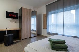 Cette chambre comprend un lit et une grande fenêtre. dans l'établissement Jade&Jabo - Moderne möblierte Serviced Apartments - Düsseldorf-Neuss, à Neuss