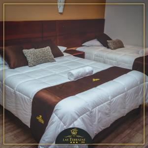 Dos camas en una habitación de hotel contigua en HOTEL LAS TERRAZAS INN, en Andahuaylas