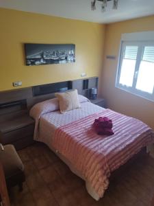 a bedroom with a bed with a pink blanket at Casa Carballa in Os Muinos