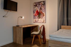 - une chambre avec un bureau, un lit et une chaise dans l'établissement Jade&Jabo - Moderne möblierte Serviced Apartments - Düsseldorf-Neuss, à Neuss