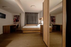 - une chambre d'hôtel avec un lit et un miroir dans l'établissement Jade&Jabo - Moderne möblierte Serviced Apartments - Düsseldorf-Neuss, à Neuss